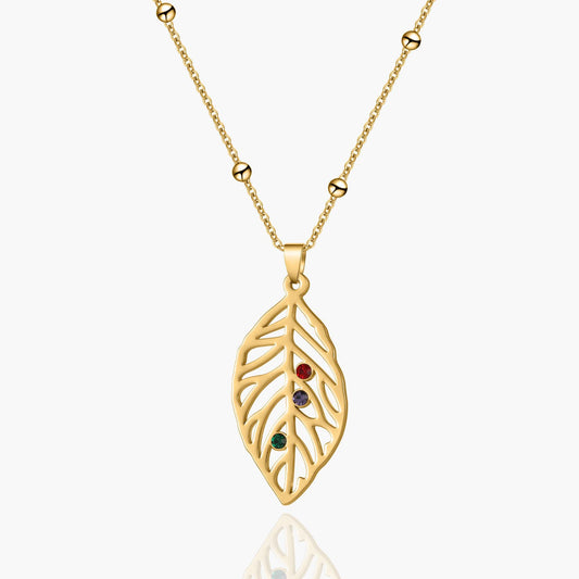Personalized gold leaf necklace with a custom birthstone, featuring intricate leaf design and a small gemstone accent.