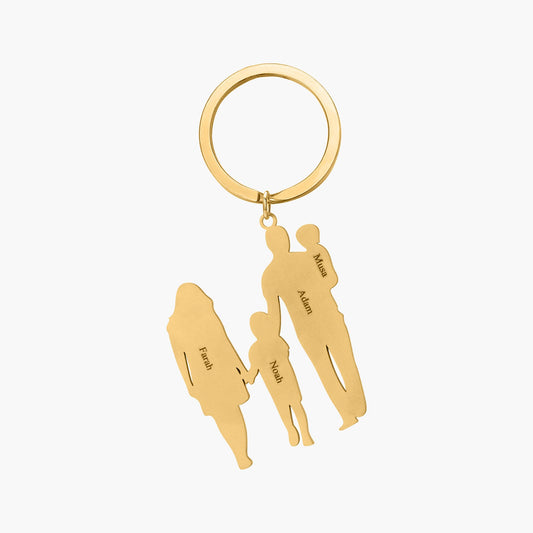 Gold custom 4-figure family keychain featuring engraved figures representing family members, attached to a metal keyring.