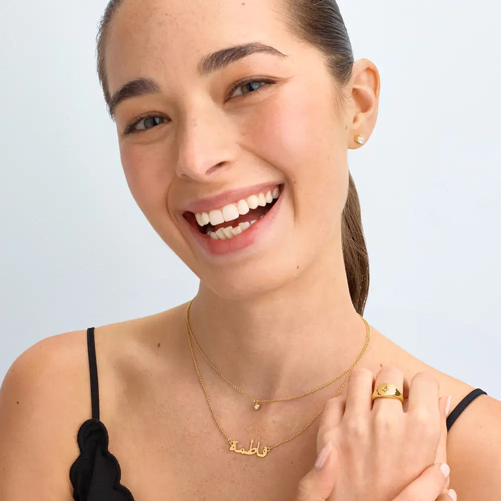 Gold finish personalized Arabic name necklace by ismijewels showcasing elegant script on a delicate chain.