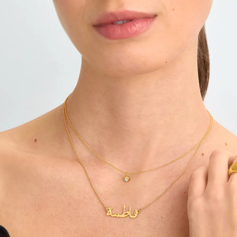 Gold finish personalized Arabic name necklace by ismijewels featuring elegant script and delicate chain detail.